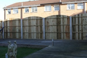 Convex closeboard garden fence panels with concrete posts (rear view)